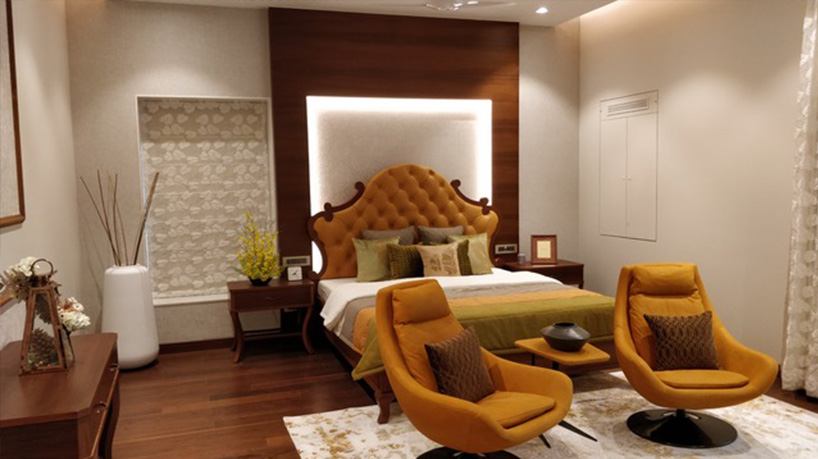 A bedroom whose interior has been styled with wooden furnishings and orange furniture and accessories.