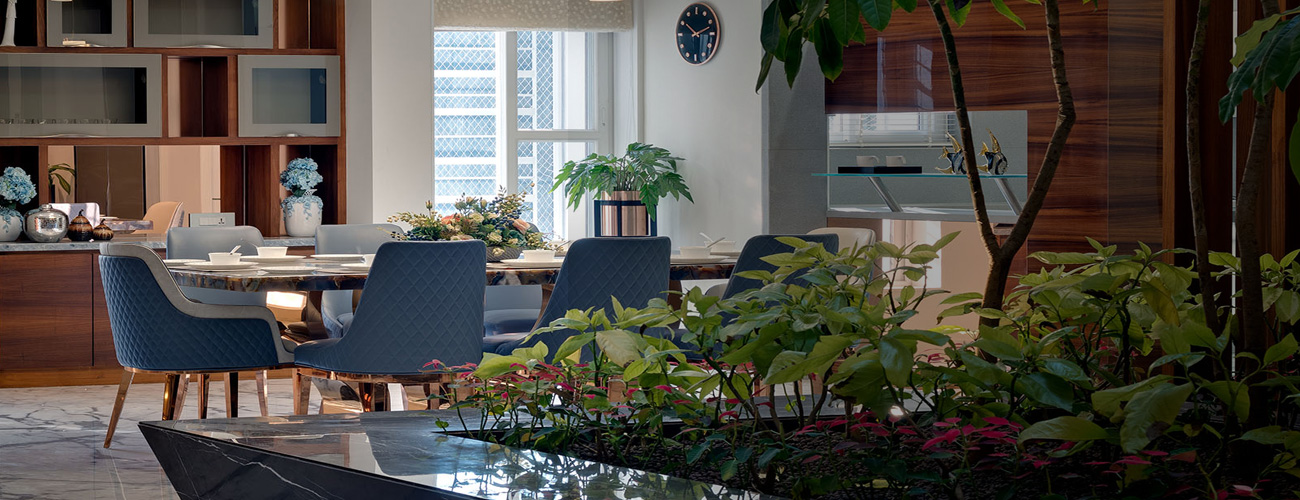 A beautiful dining area decorated in rich blues and surrounded by plants and nature.